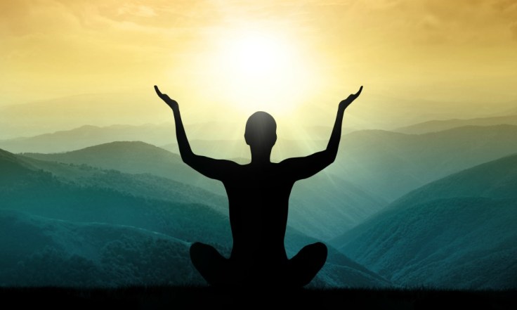 Yoga and meditation. Silhouette of man in the mountain